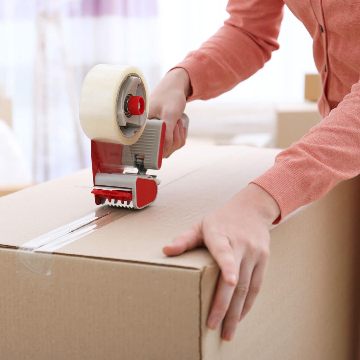 Woman taping up a packing box.